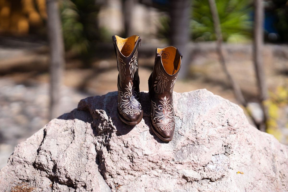Close-up of a cowboy boot toe on rocky ground